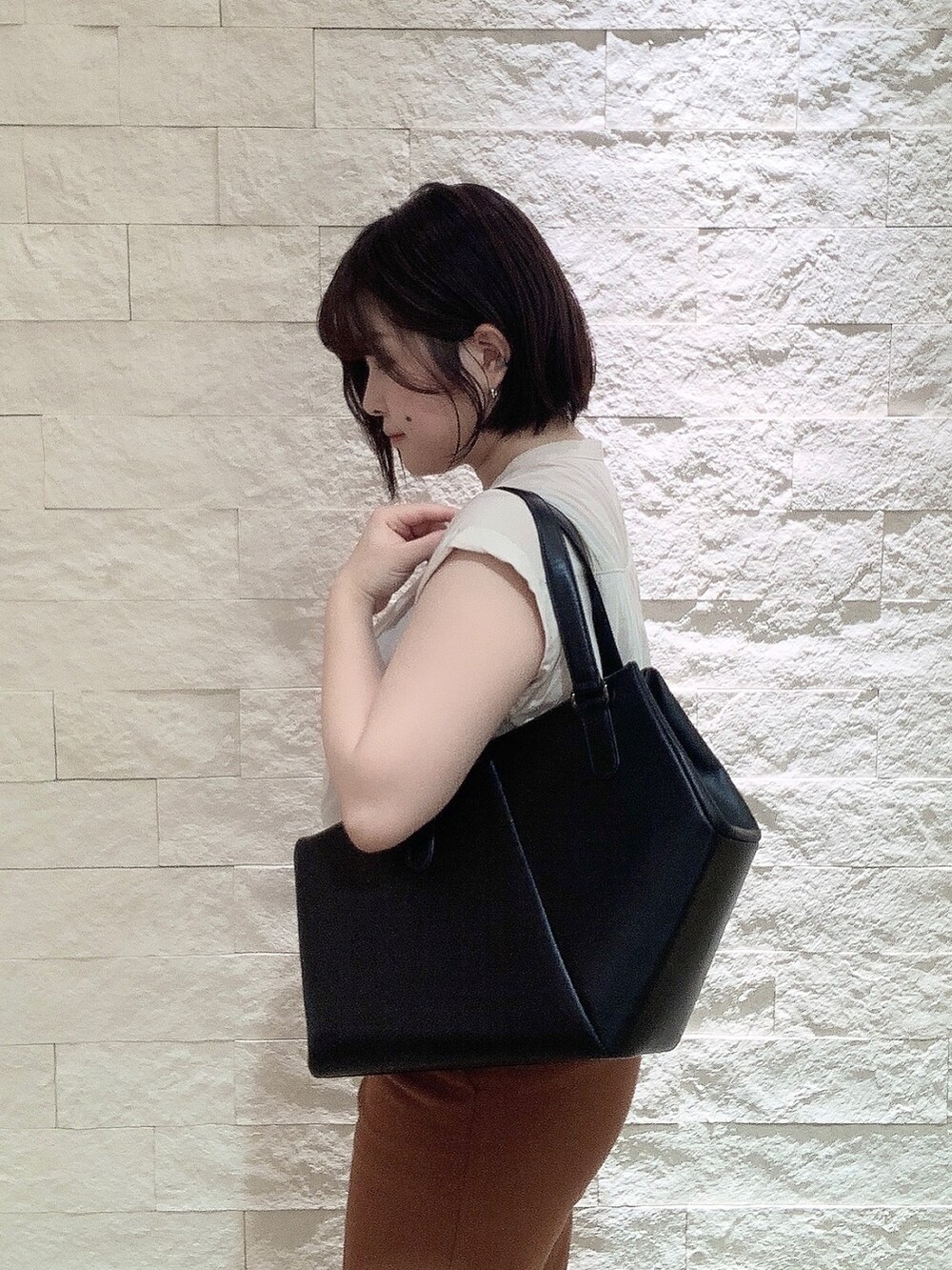 ブラック系のトートバッグを着用したレディースの夏コーディネートの2枚目の写真