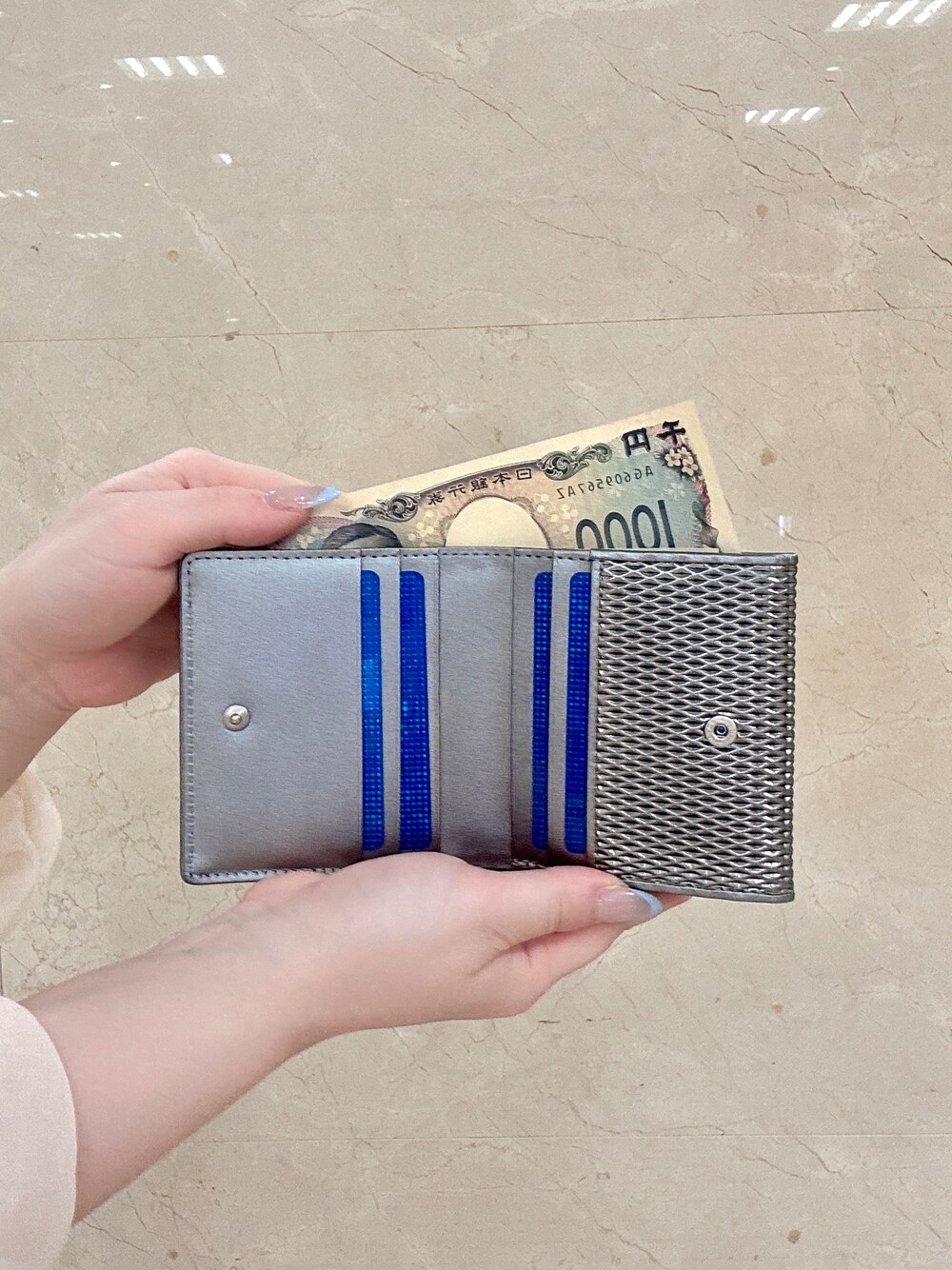 ゴールド系の名刺入れ、ゴールド系の財布、シルバー系の財布を着用したレディースの夏コーディネートの5枚目の写真