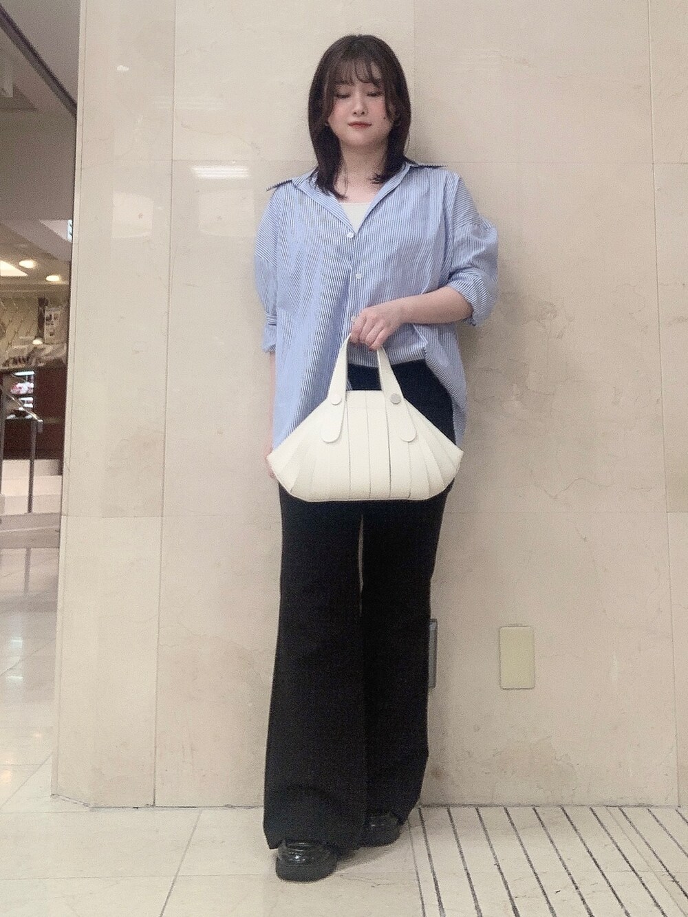 ホワイト系のハンドバッグを着用したレディースの夏コーディネートの3枚目の写真
