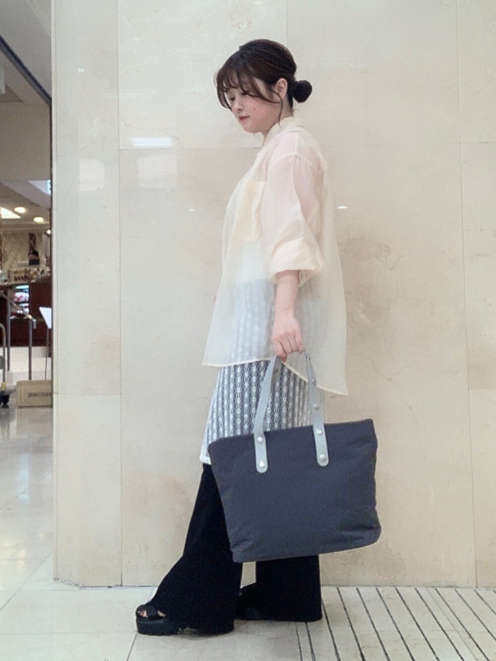 グレー系のトートバッグを着用したレディースの夏コーディネートの3枚目の写真