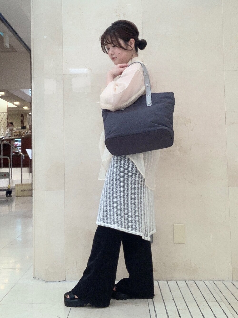 グレー系のトートバッグを着用したレディースの夏コーディネートの2枚目の写真