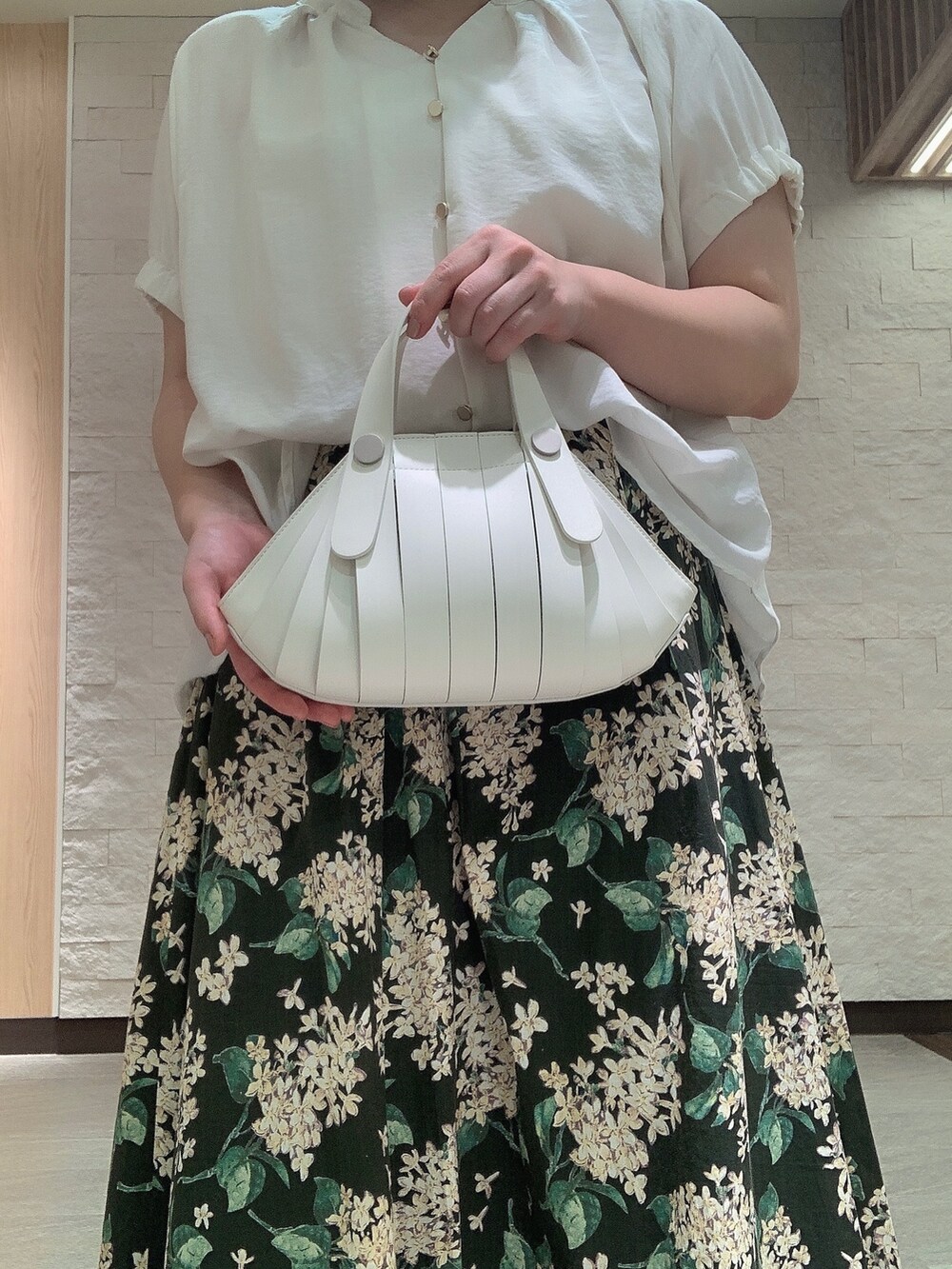 ホワイト系のハンドバッグを着用したレディースの夏コーディネートの3枚目の写真