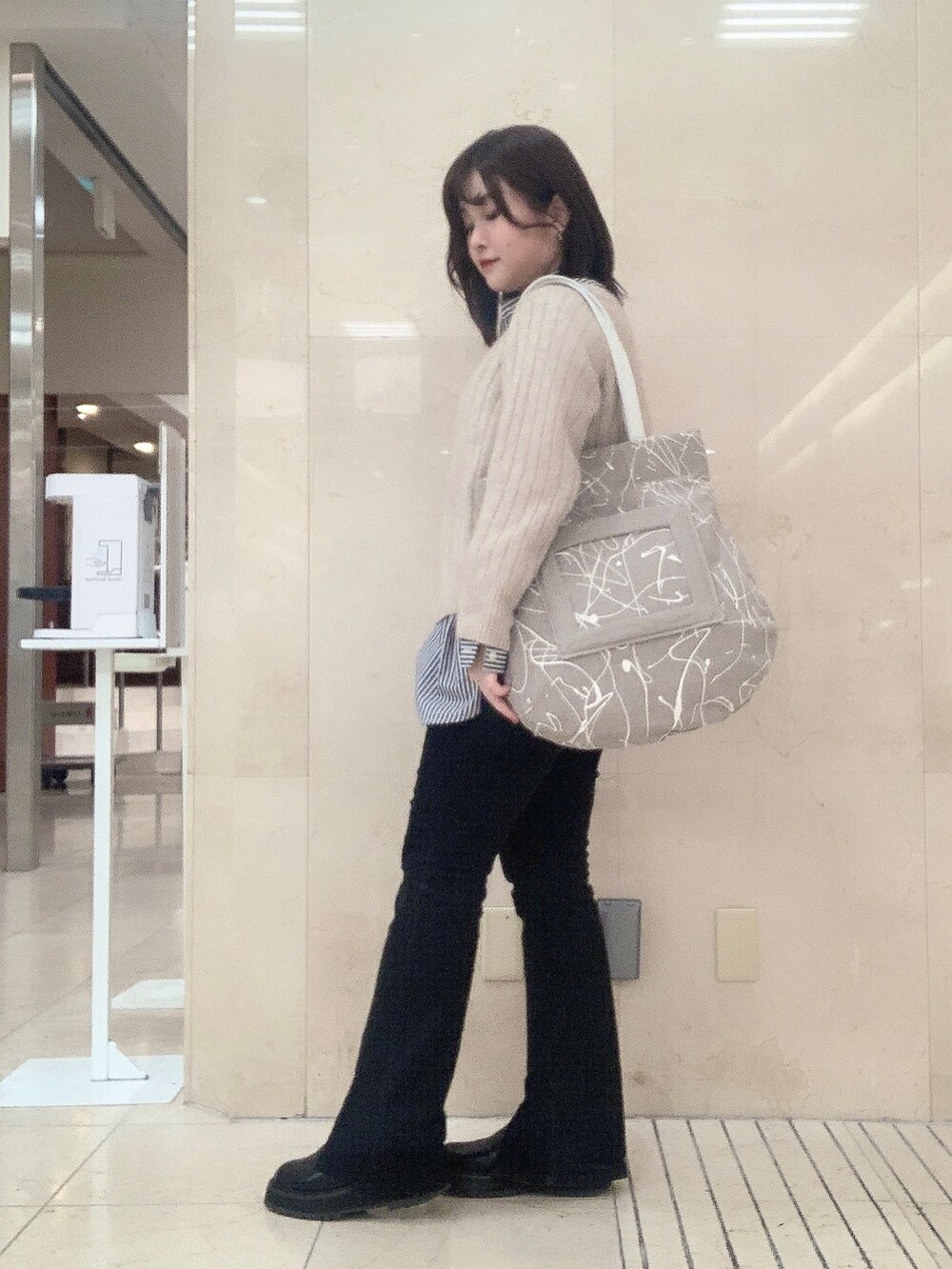 ベージュ系のトートバッグを着用したレディースの冬コーディネートの2枚目の写真