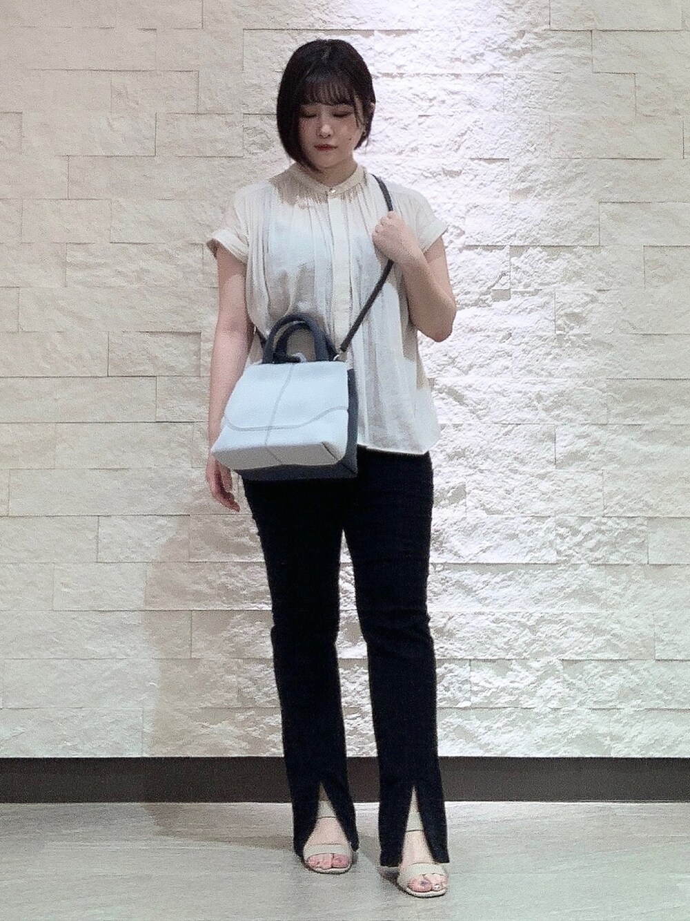 ホワイト系のハンドバッグを着用したレディースの夏コーディネートの3枚目の写真