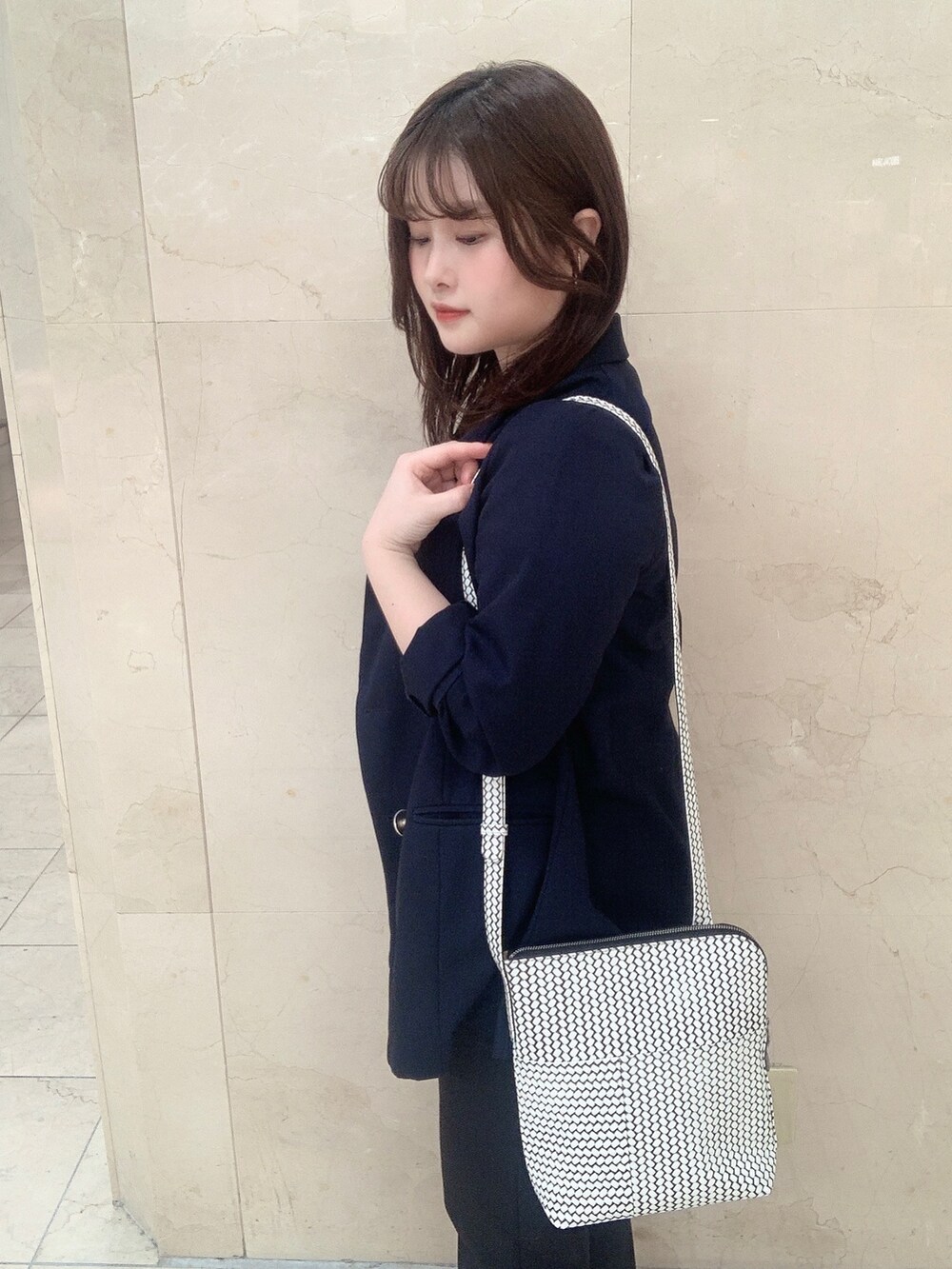 ホワイト系のショルダーバッグを着用したレディースの夏コーディネートの2枚目の写真