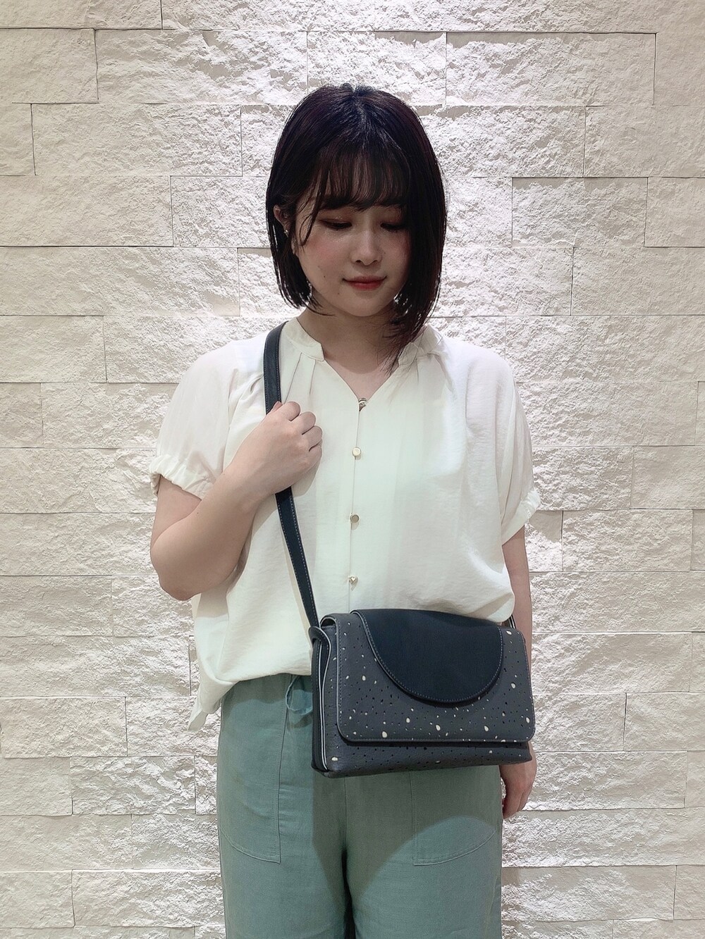 グレー系のショルダーバッグを着用したレディースの夏コーディネートの2枚目の写真