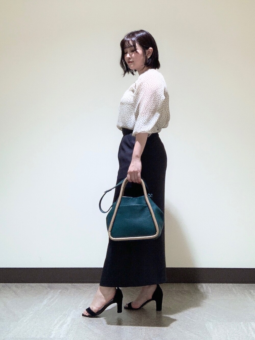 グリーン系のショルダーバッグを着用したレディースの夏コーディネートの2枚目の写真