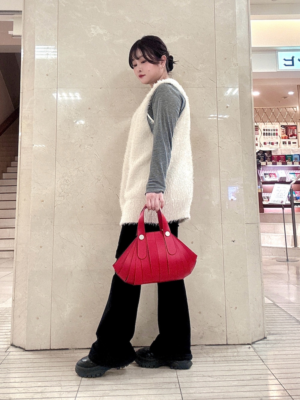 レッド系のハンドバッグを着用したレディースの冬コーディネートの6枚目の写真