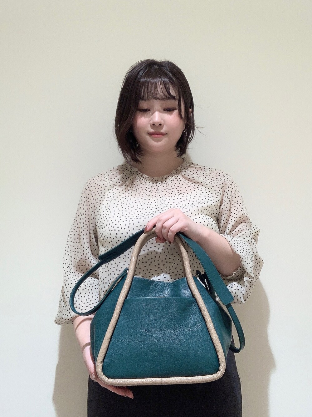 グリーン系のショルダーバッグを着用したレディースの夏コーディネートの3枚目の写真