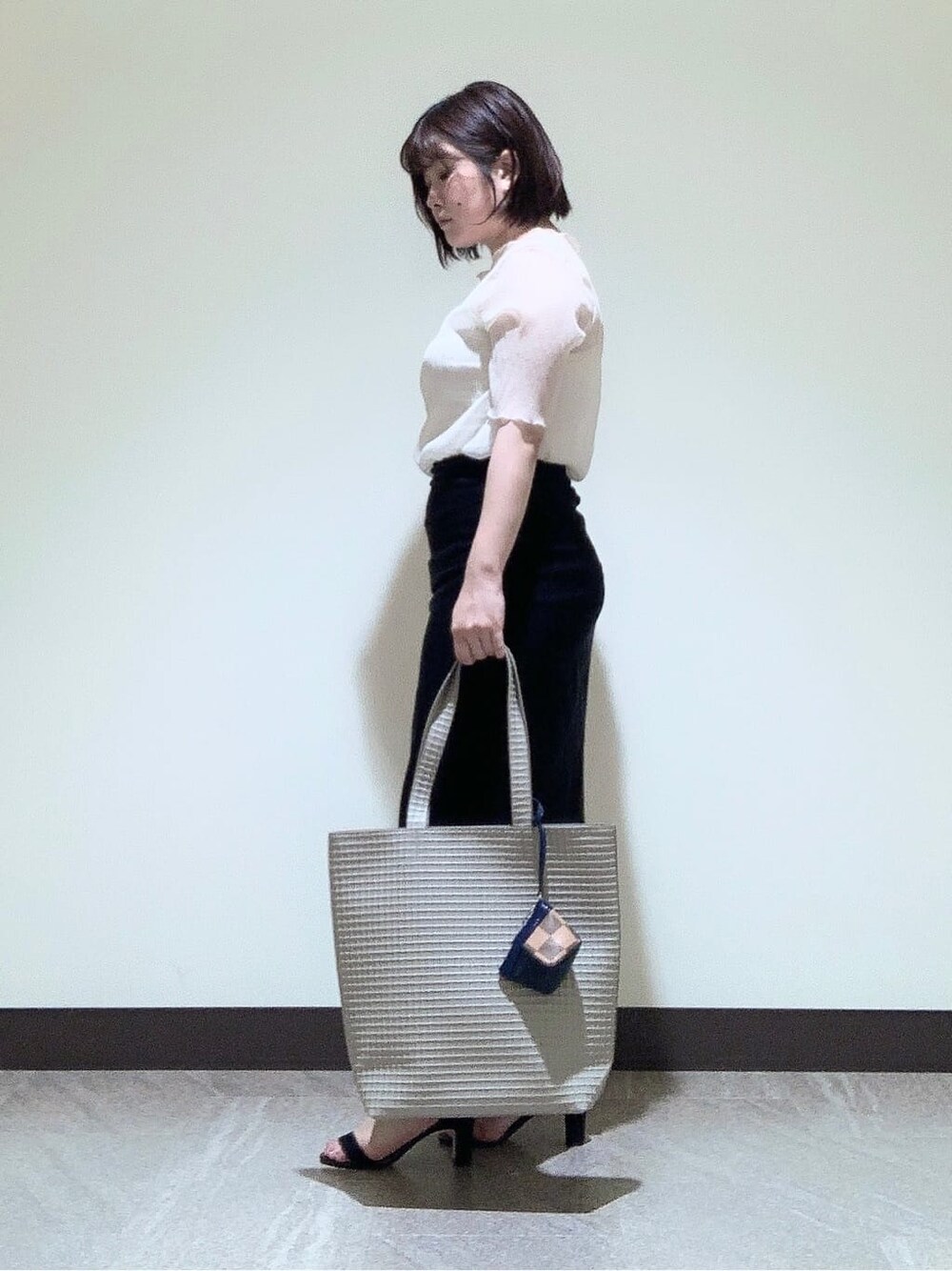ベージュ系のトートバッグ、ベージュ系のポーチを着用したレディースの夏コーディネートの4枚目の写真