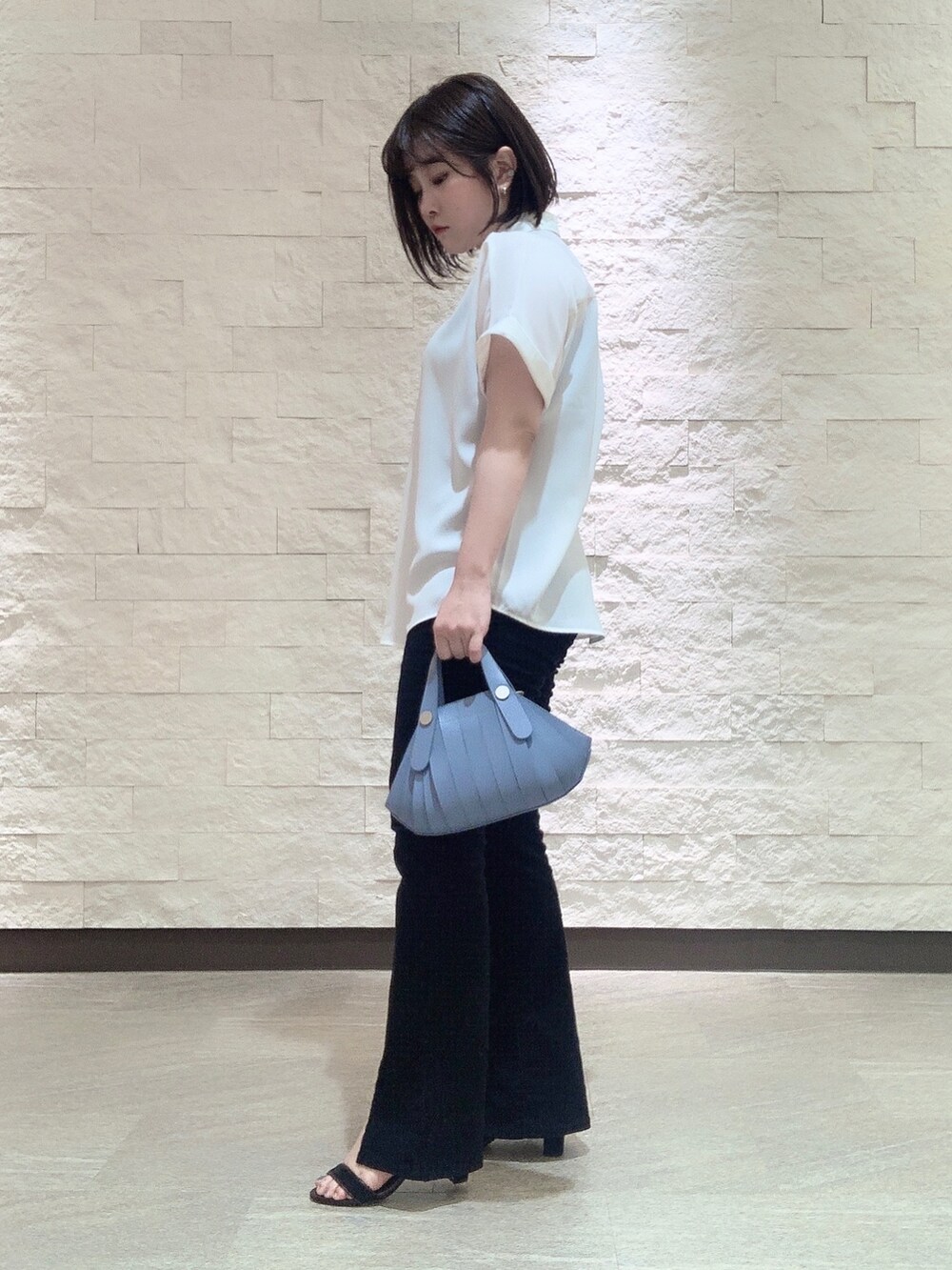 ブルー系のハンドバッグを着用したレディースの夏コーディネートの2枚目の写真