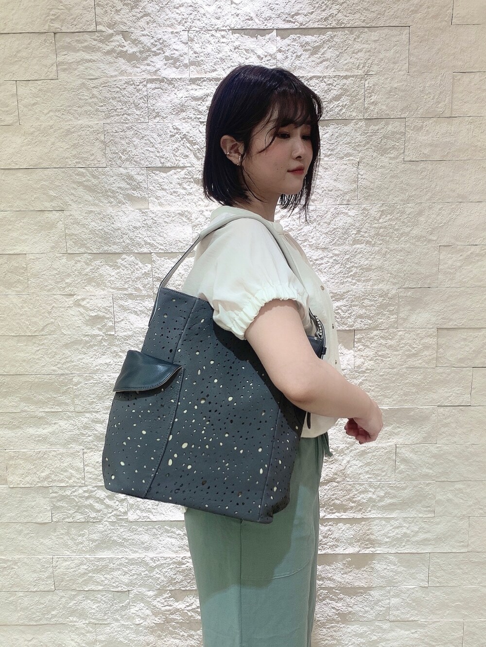 グレー系のショルダーバッグを着用したレディースの夏コーディネートの2枚目の写真