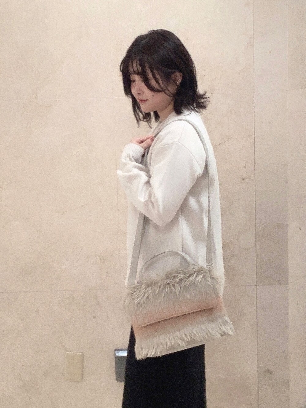 ベージュ系のショルダーバッグを着用したレディースの秋コーディネートの2枚目の写真