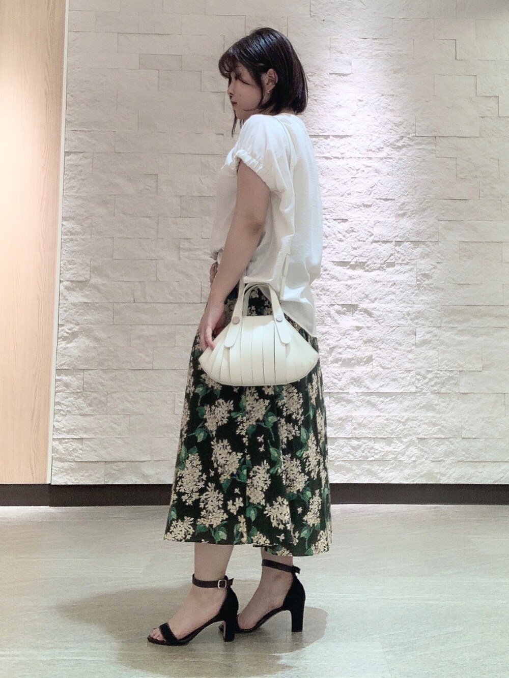 ホワイト系のハンドバッグを着用したレディースの夏コーディネートの2枚目の写真