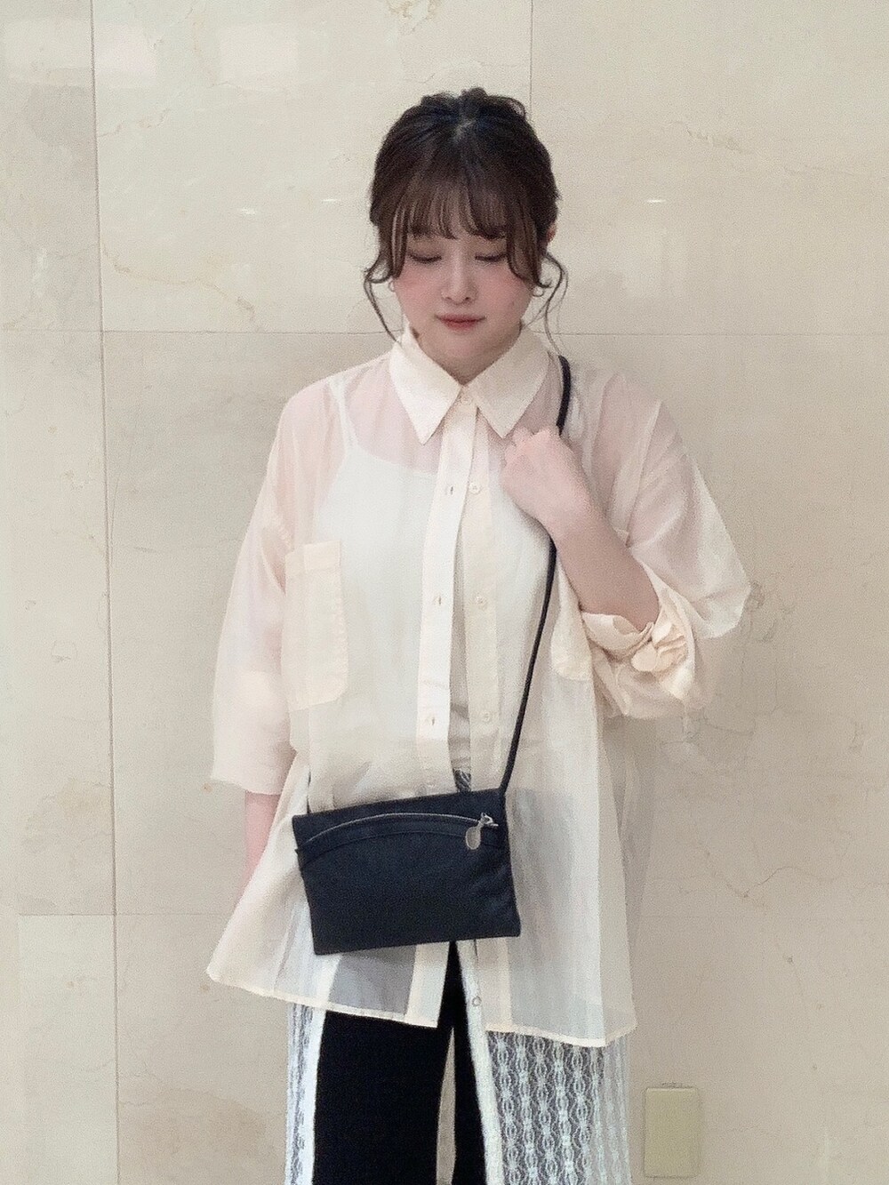 ブラック系のショルダーバッグを着用したレディースの夏コーディネートの3枚目の写真