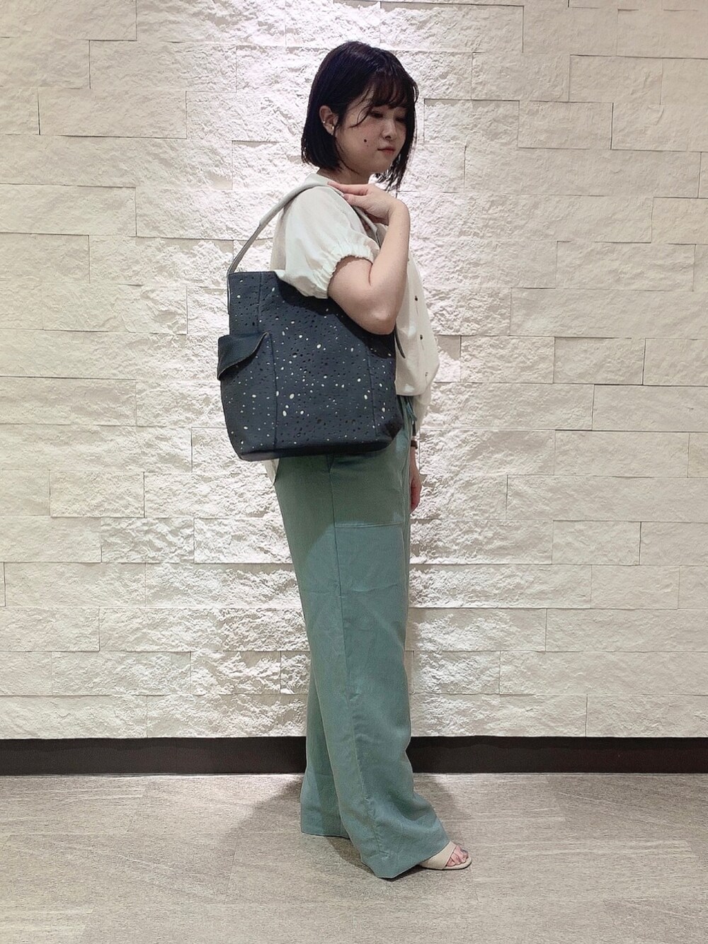 グレー系のショルダーバッグを着用したレディースの夏コーディネートの3枚目の写真