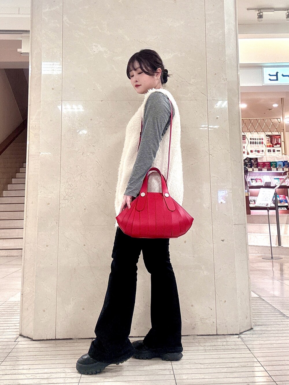 レッド系のハンドバッグを着用したレディースの冬コーディネートの4枚目の写真