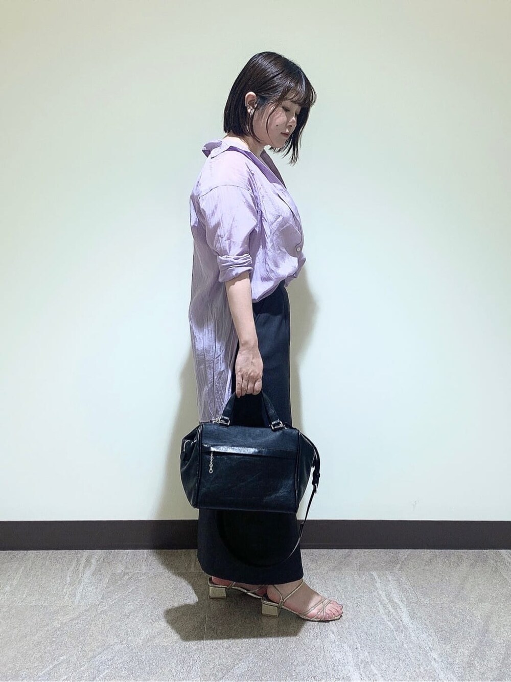 ブラック系のハンドバッグを着用したレディースの夏コーディネートの2枚目の写真