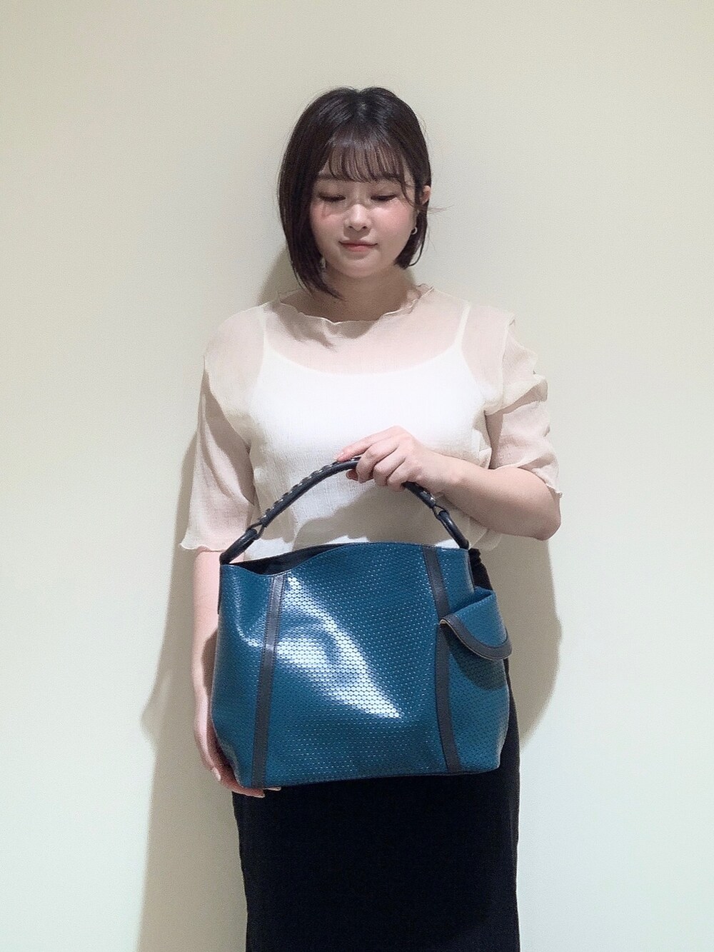 ブルー系のショルダーバッグを着用したレディースの夏コーディネートの2枚目の写真