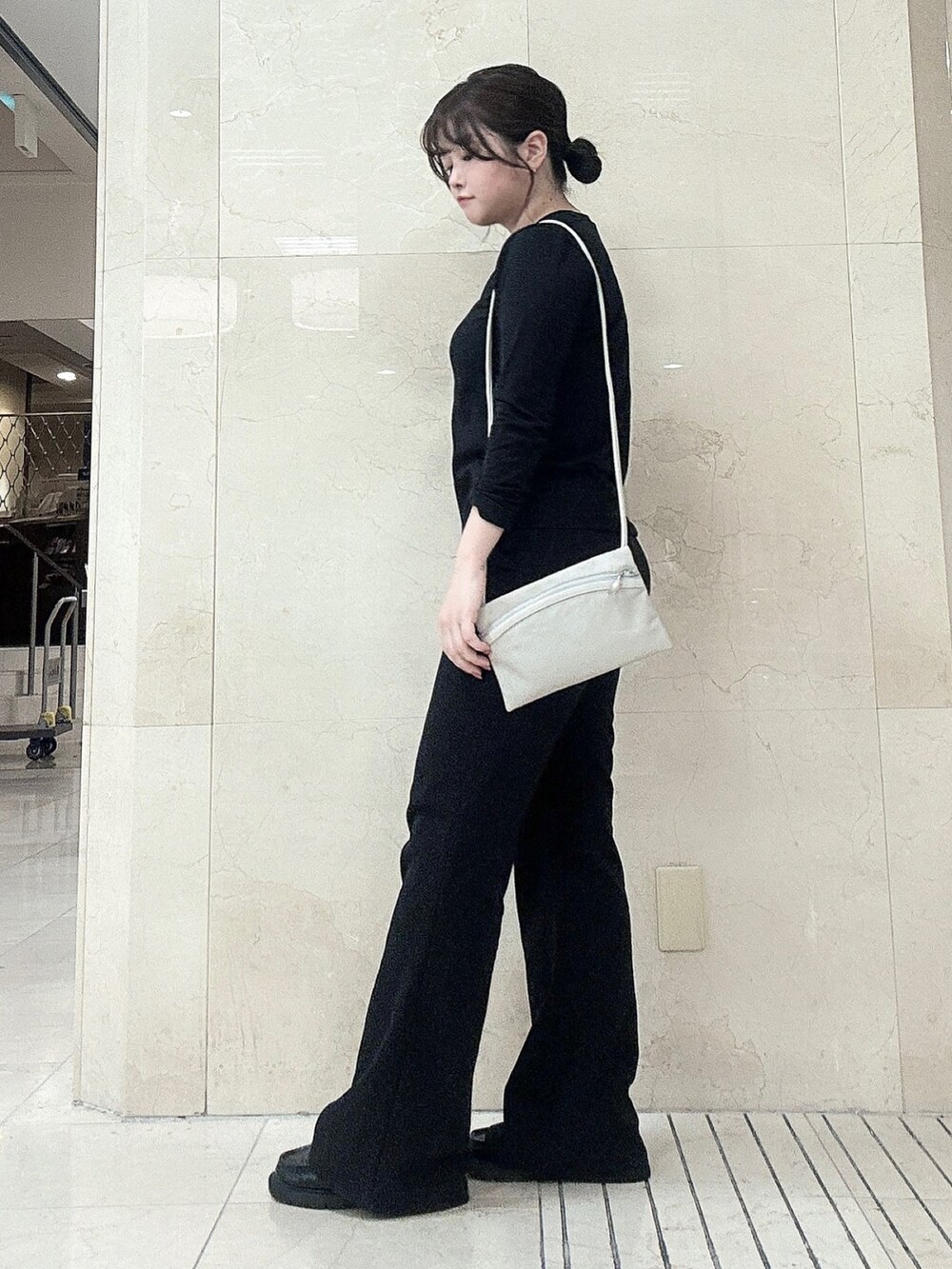 グレー系のショルダーバッグを着用したレディースの秋コーディネートの2枚目の写真