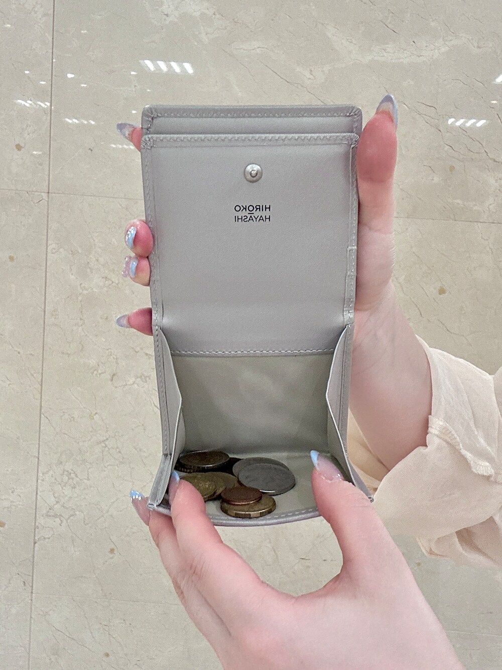 ゴールド系の名刺入れ、ゴールド系の財布、シルバー系の財布を着用したレディースの夏コーディネートの8枚目の写真