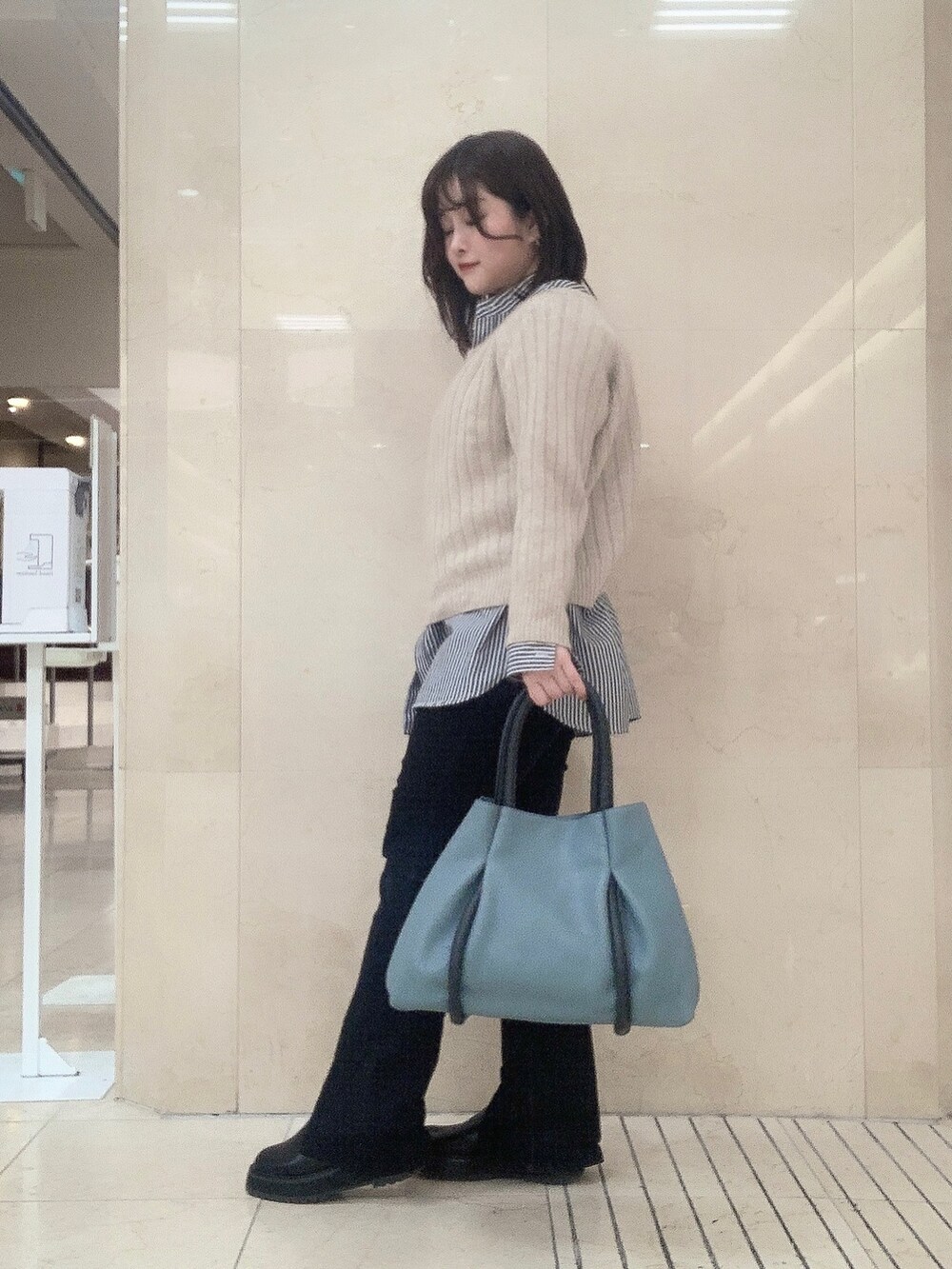 ブルー系のトートバッグを着用したレディースの冬コーディネートの3枚目の写真