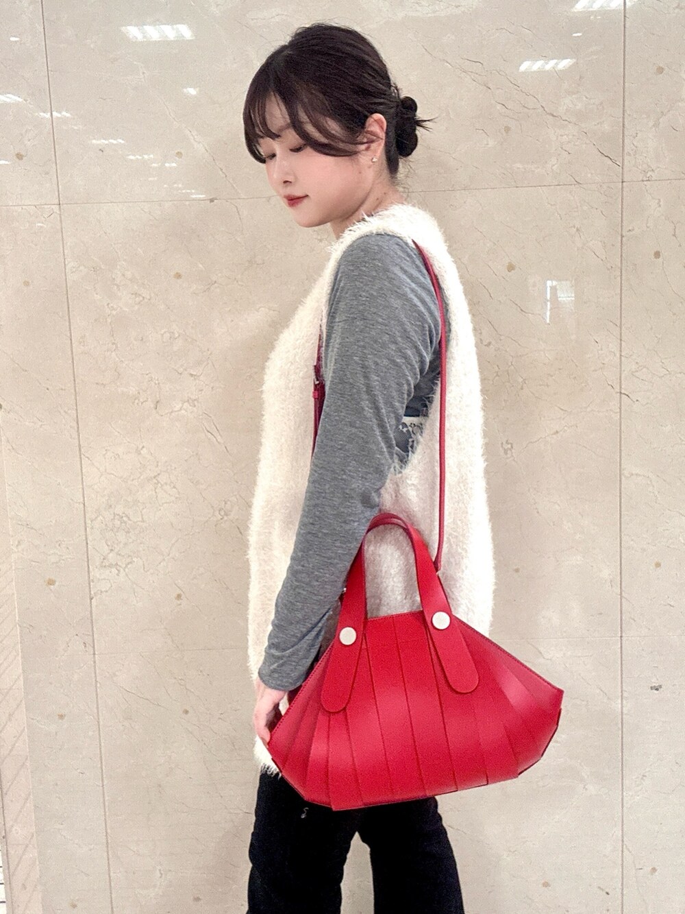 レッド系のハンドバッグを着用したレディースの冬コーディネートの3枚目の写真
