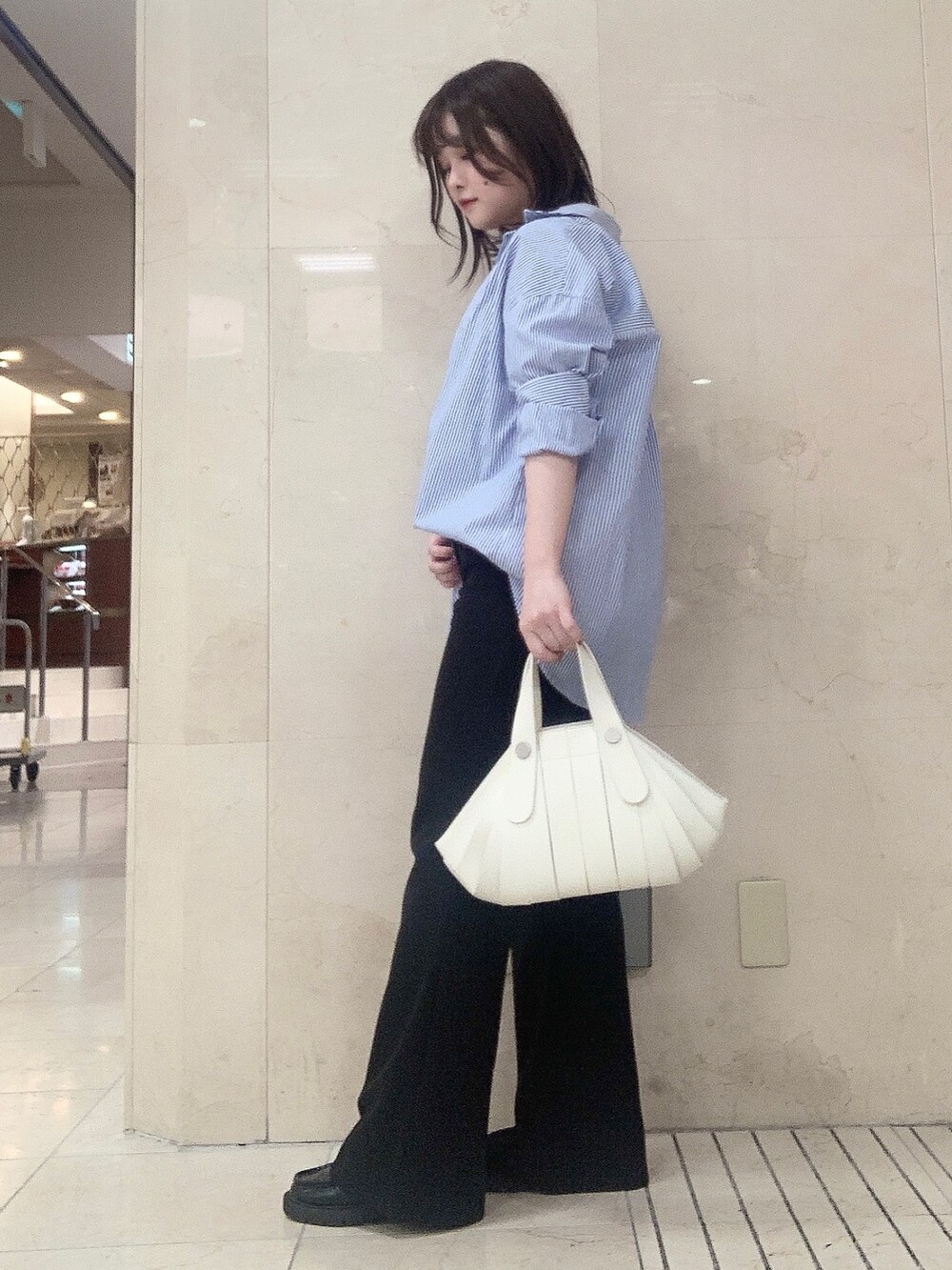 ホワイト系のハンドバッグを着用したレディースの夏コーディネートの2枚目の写真