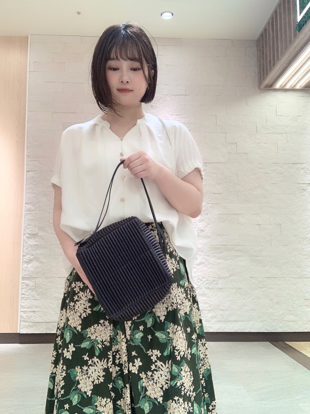 ブルー系のハンドバッグを着用したレディースの夏コーディネートの2枚目の写真