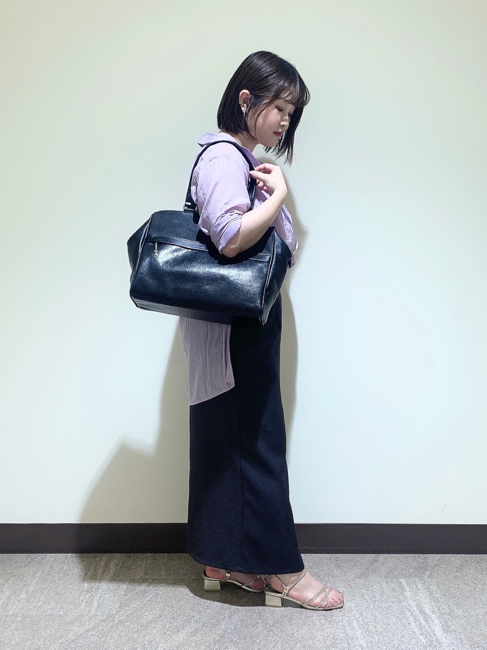 ブラック系のトートバッグを着用したレディースの夏コーディネートの3枚目の写真
