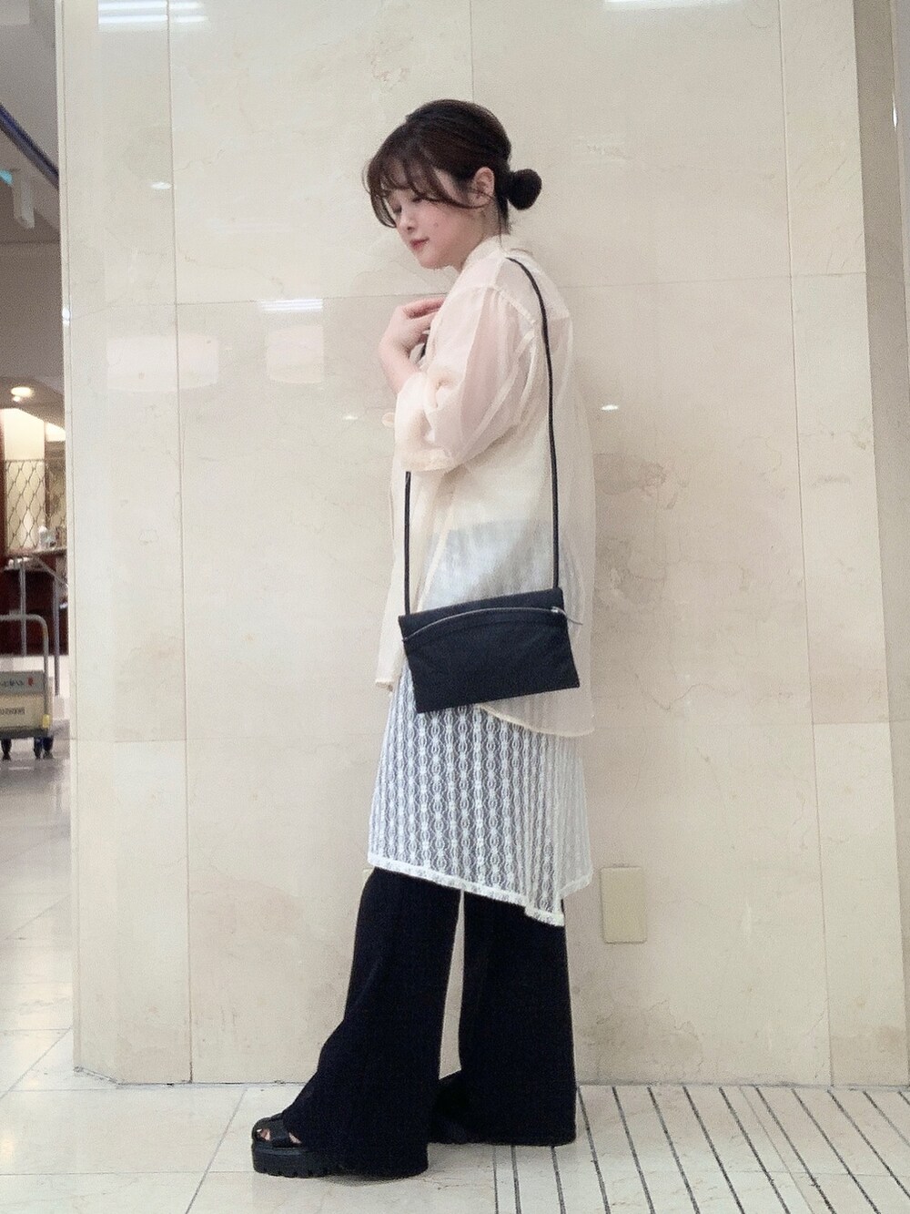 ブラック系のショルダーバッグを着用したレディースの夏コーディネートの2枚目の写真