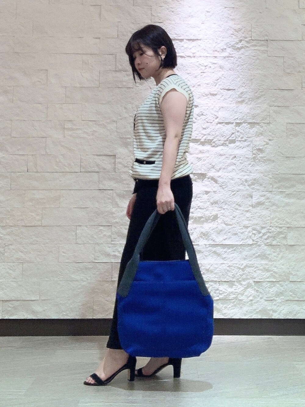 ブルー系のトートバッグを着用したレディースの夏コーディネートの3枚目の写真