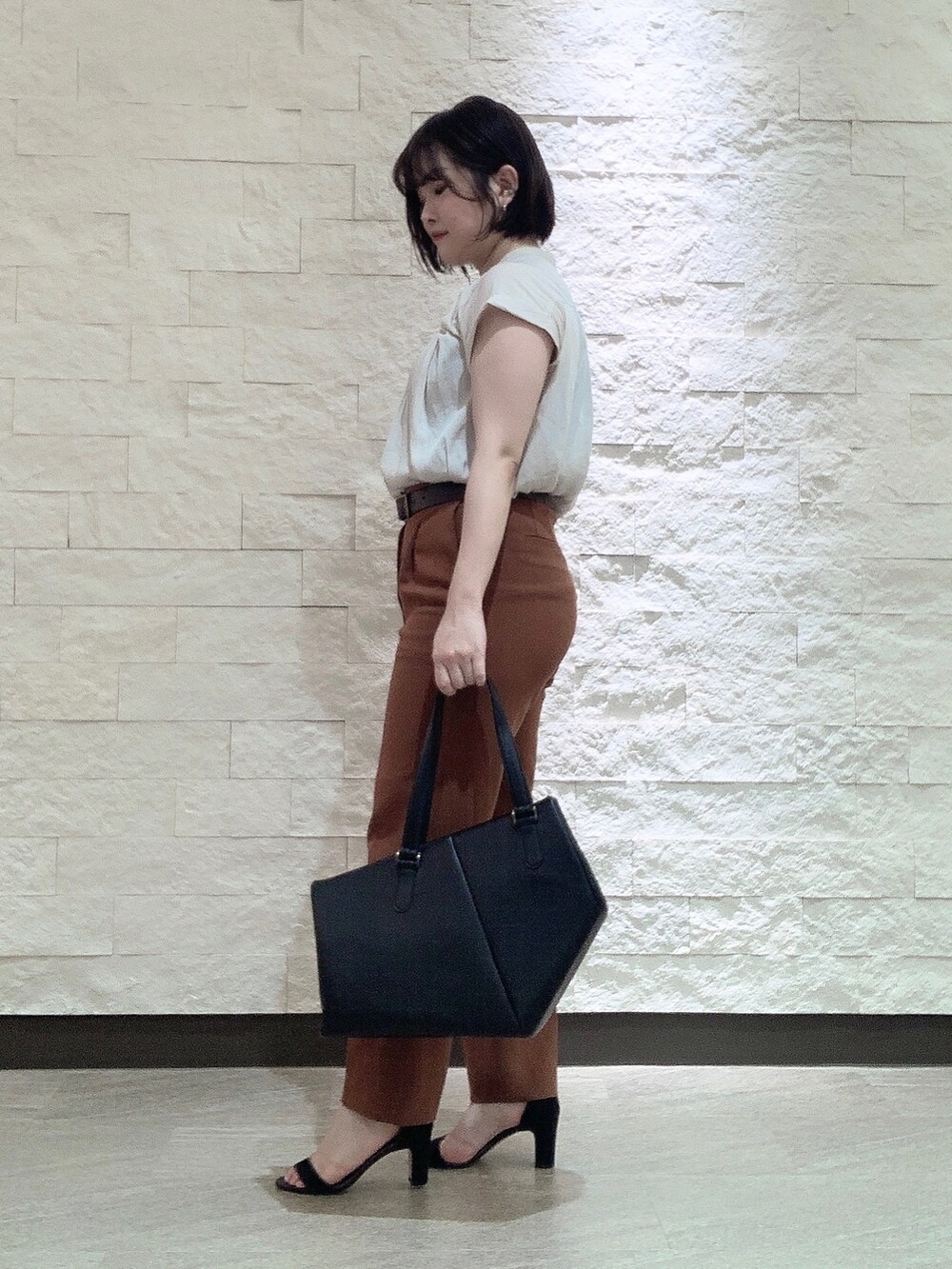 ブラック系のトートバッグを着用したレディースの夏コーディネートの3枚目の写真