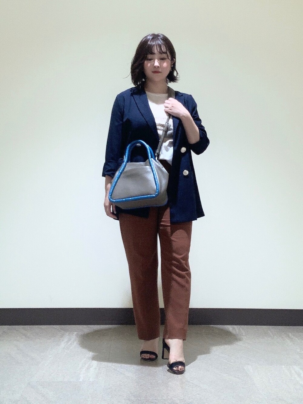 グレー系のショルダーバッグを着用したレディースの夏コーディネートの3枚目の写真