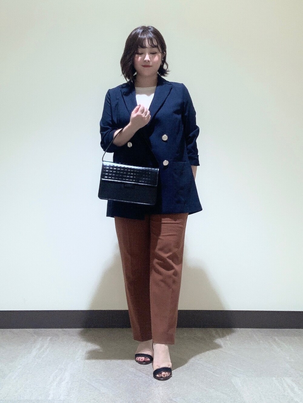 ブラック系のハンドバッグを着用したレディースの夏コーディネートの2枚目の写真