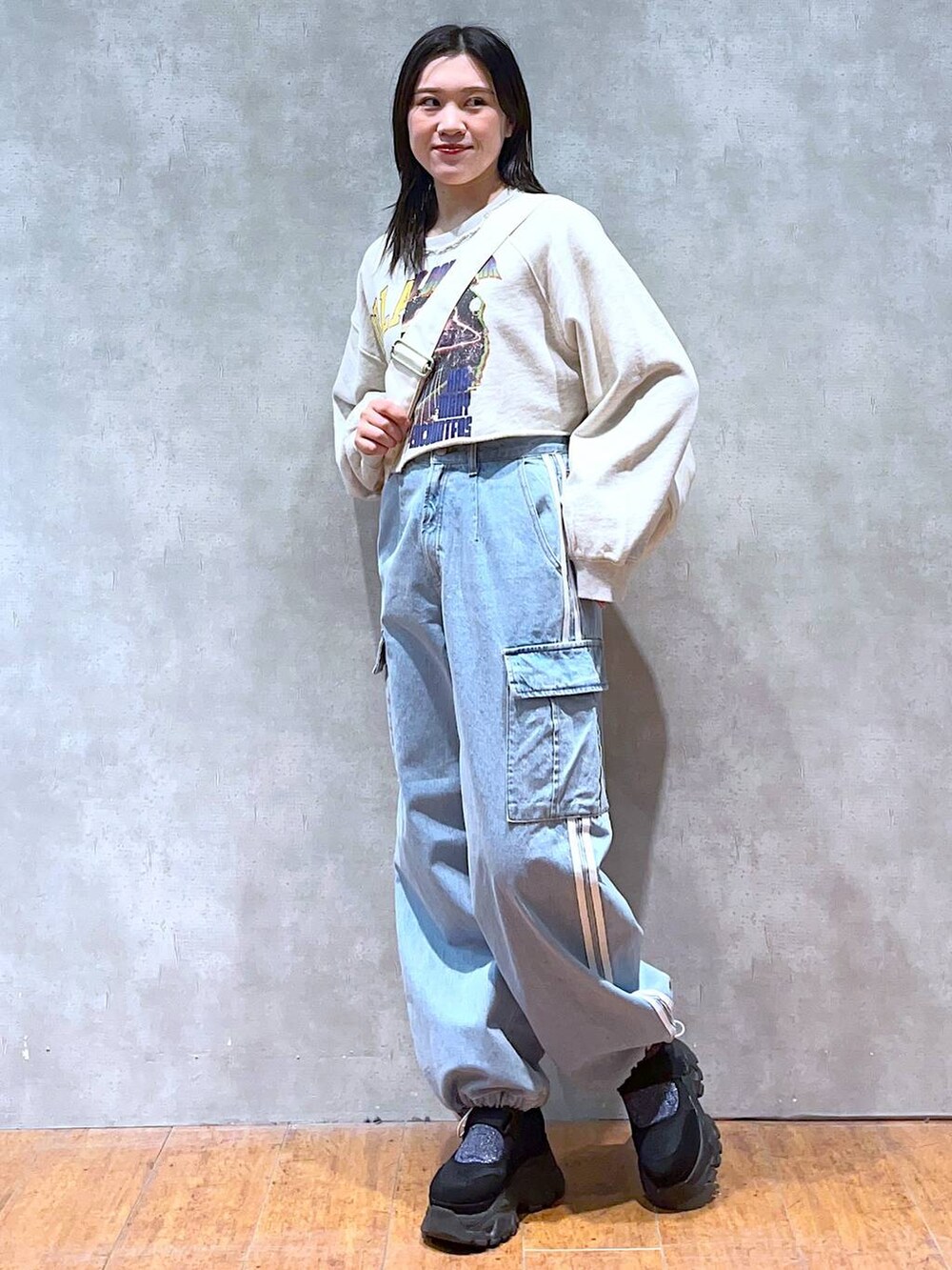 ベージュ系のスウェット、ホワイト系のショルダーバッグ、ブラック系のスニーカーを着用したレディースの春コーディネートの4枚目の写真