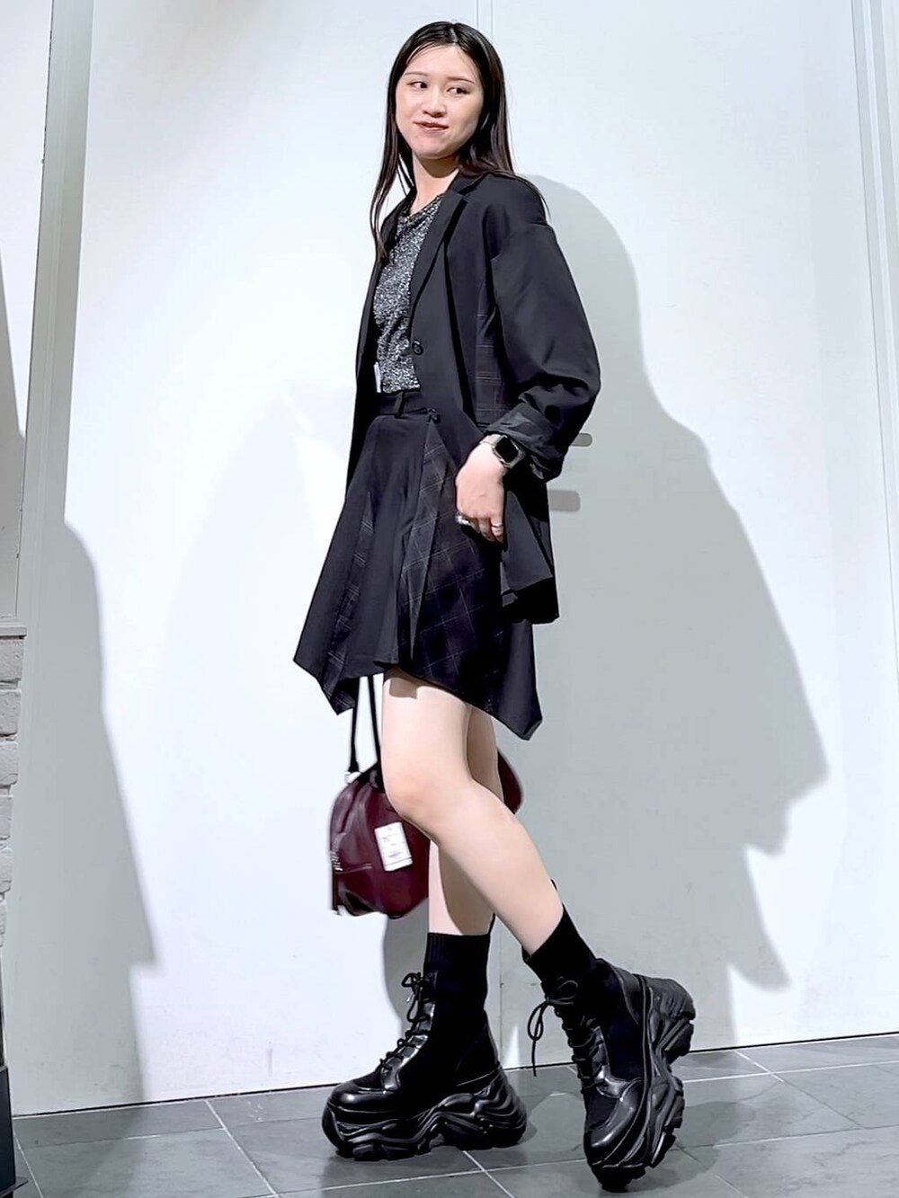 ブラック系のブーツ、シルバー系のTシャツ/カットソー、ブラック系のスカートを着用したレディースの秋コーディネートの3枚目の写真