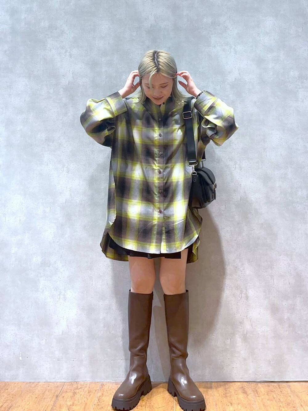 ブラウン系のブーツ、ブラック系のショルダーバッグ、グリーン系のシャツ/ブラウスを着用したレディースの秋コーディネートの3枚目の写真