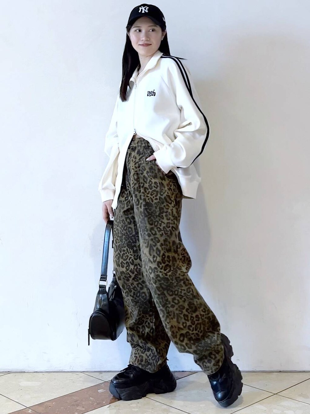 ブラック系のスニーカー、その他のデニムパンツ、ホワイト系のブルゾンを着用したレディースの春コーディネートの3枚目の写真