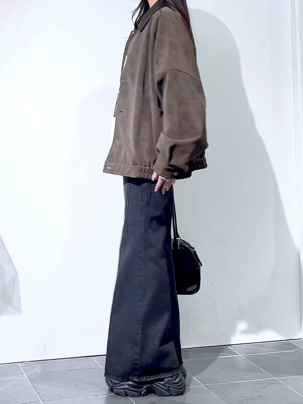 ブラック系のスニーカー、ブラック系のデニムパンツ、ブラック系のボストンバッグを着用したレディースの秋コーディネートの8枚目の写真