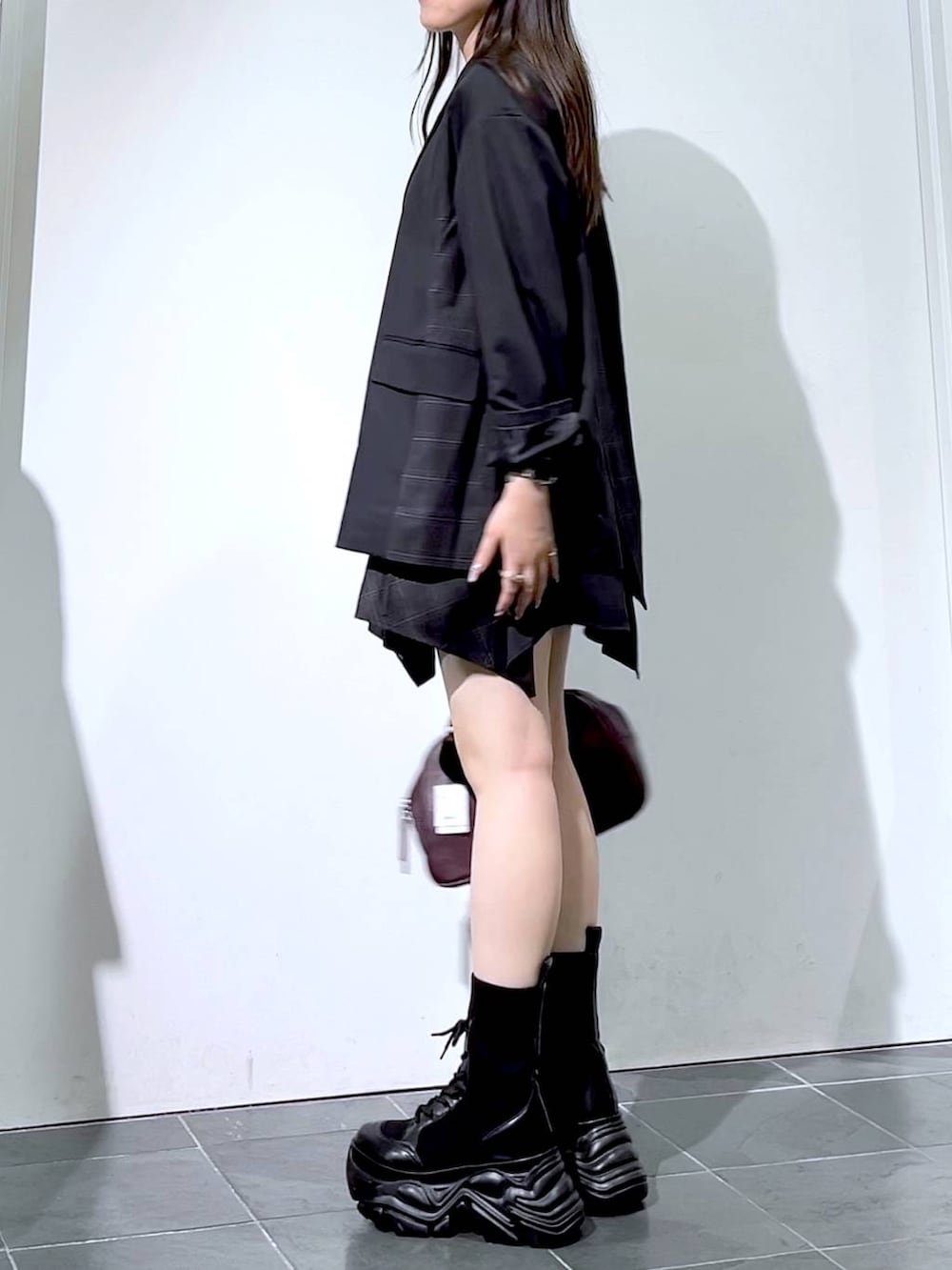 ブラック系のブーツ、シルバー系のTシャツ/カットソー、ブラック系のスカートを着用したレディースの秋コーディネートの6枚目の写真