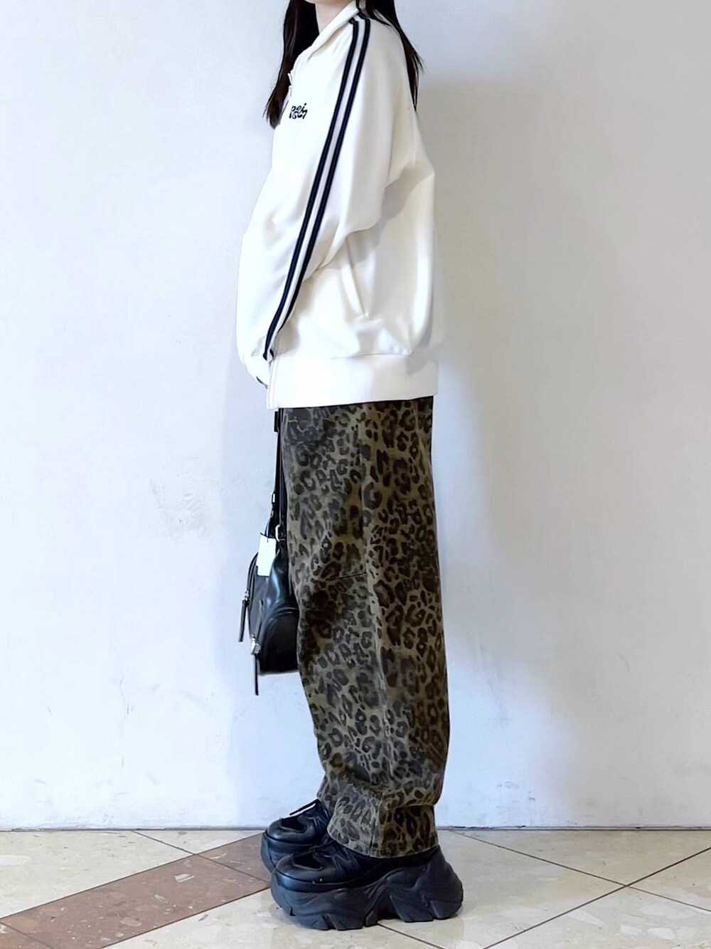 ブラック系のスニーカー、その他のデニムパンツ、ホワイト系のブルゾンを着用したレディースの春コーディネートの6枚目の写真