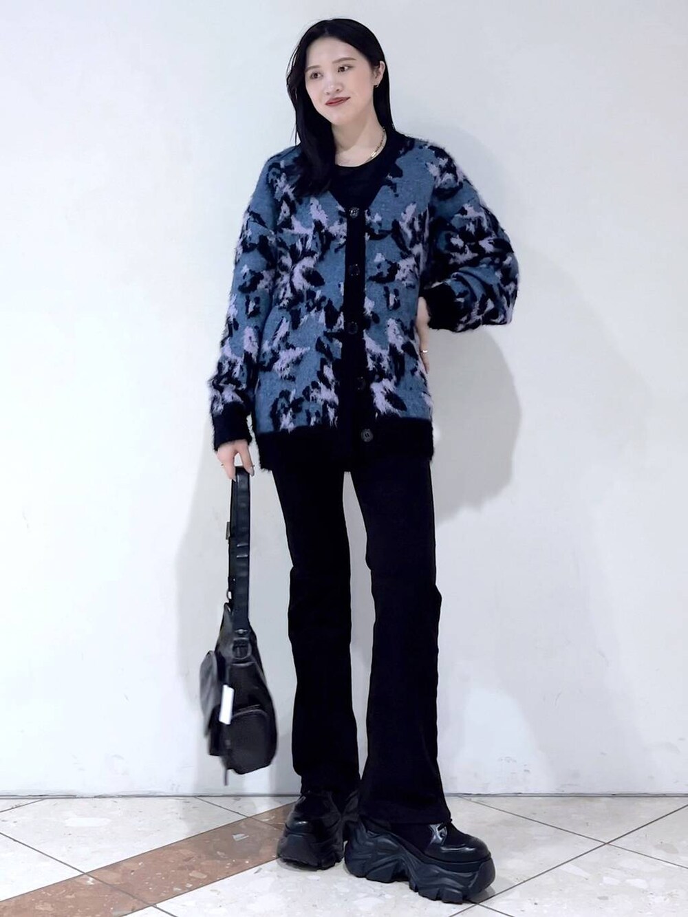 ブラック系のブーツ、ブラック系のショルダーバッグ、ブルー系のニット/セーターを着用したレディースの冬コーディネートの5枚目の写真