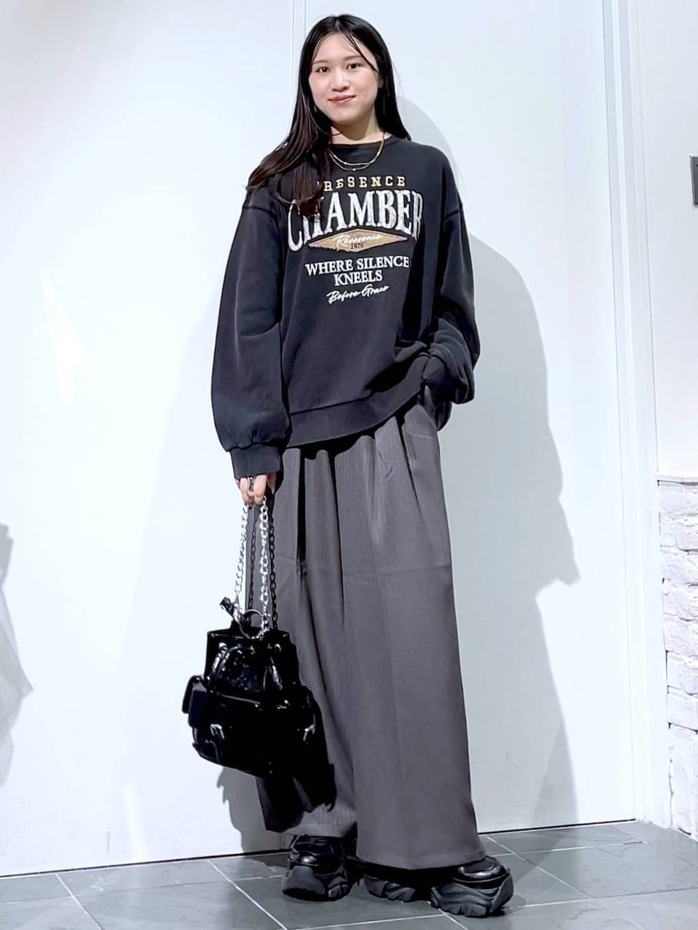 ブラック系のスニーカー、グレー系のスウェット、ブラック系のショルダーバッグを着用したレディースの秋コーディネートの4枚目の写真