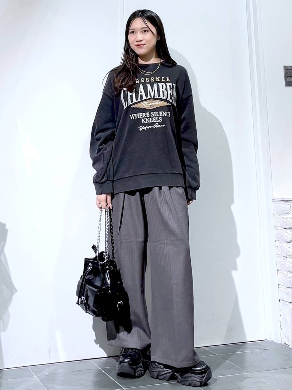 ブラック系のスニーカー、グレー系のスウェット、ブラック系のショルダーバッグを着用したレディースの秋コーディネートの5枚目の写真