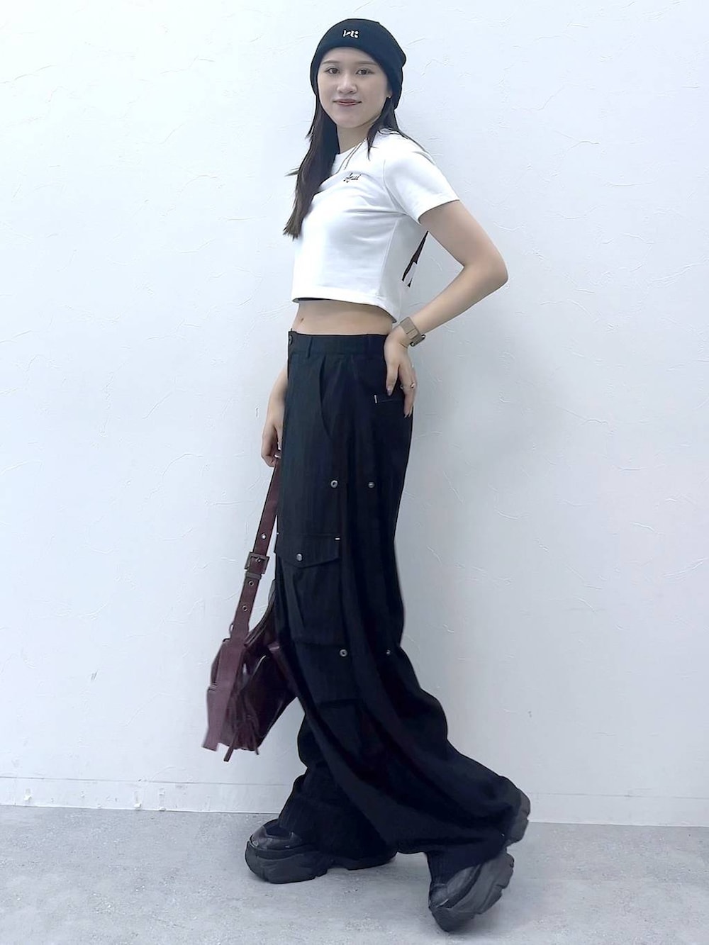 ブラック系のスニーカー、レッド系のショルダーバッグ、その他のカーゴパンツを着用したレディースの夏コーディネートの4枚目の写真