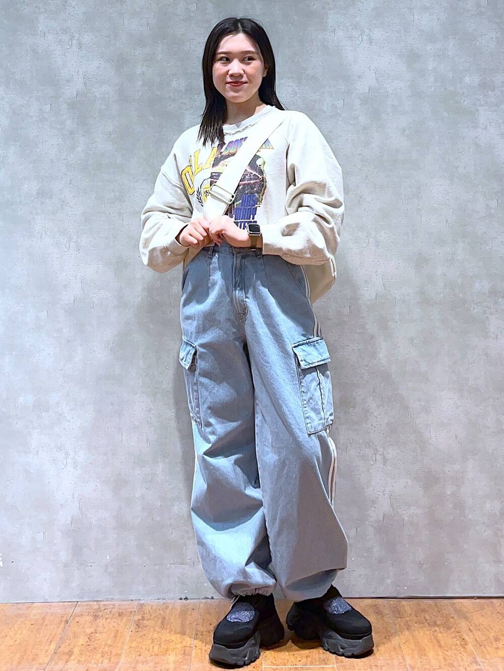 ベージュ系のスウェット、ホワイト系のショルダーバッグ、ブラック系のスニーカーを着用したレディースの春コーディネートの5枚目の写真