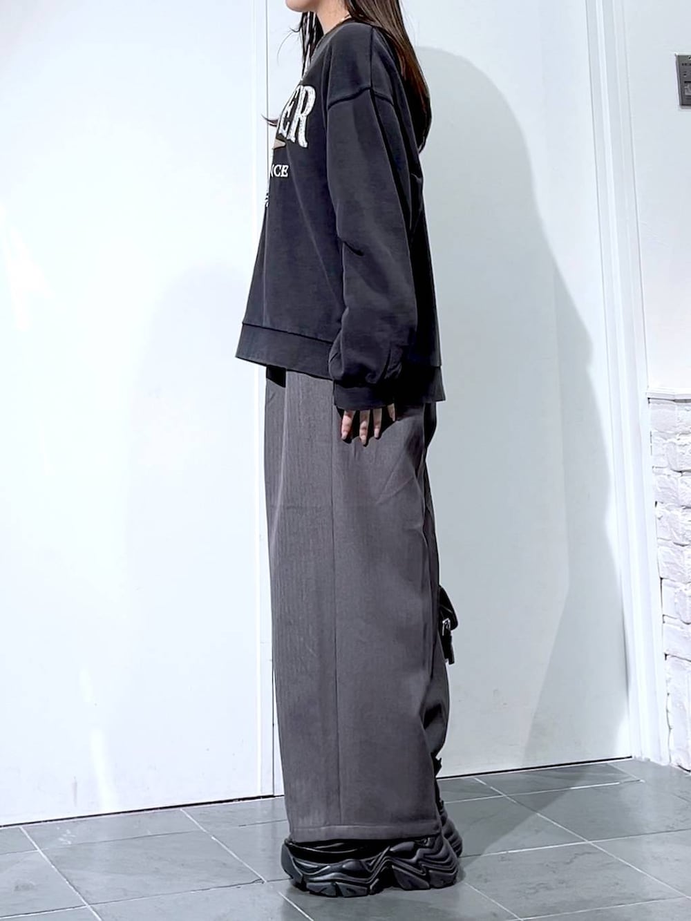 ブラック系のスニーカー、グレー系のスウェット、ブラック系のショルダーバッグを着用したレディースの秋コーディネートの6枚目の写真