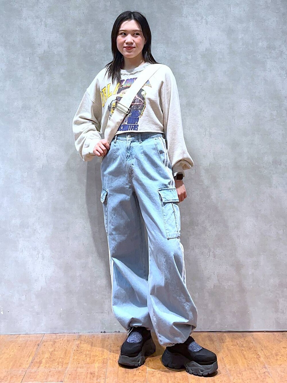 ベージュ系のスウェット、ホワイト系のショルダーバッグ、ブラック系のスニーカーを着用したレディースの春コーディネートの6枚目の写真