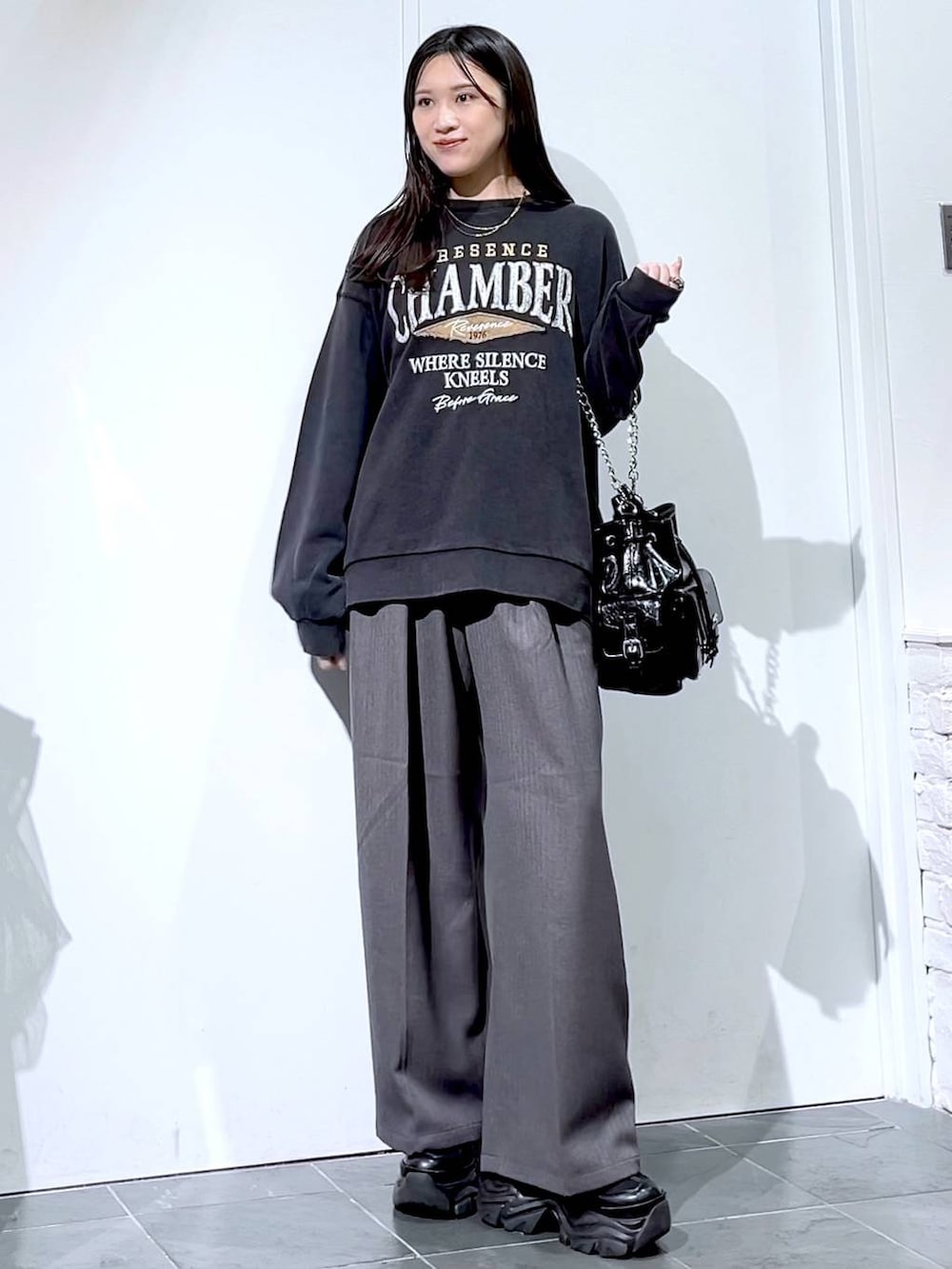 ブラック系のスニーカー、グレー系のスウェット、ブラック系のショルダーバッグを着用したレディースの秋コーディネートの3枚目の写真